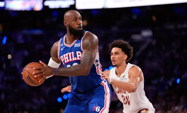 Philadelphia 76ers' LeBron James, left, tries to get past Cleveland Cavaliers' Tyrese Proctor during the first half of an NBA basketball game Thursday, Oct. 22, 2026, in Philadelphia. (AP Photo/Matt Slocum)
