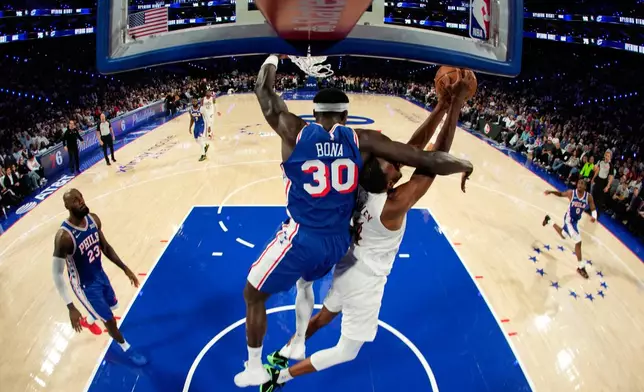 Cleveland Cavaliers' Evan Mobley, right, tries to get a shot past Philadelphia 76ers' Adem Bona during the first half of an NBA basketball game Thursday, Oct. 22, 2026, in Philadelphia. (AP Photo/Matt Slocum)