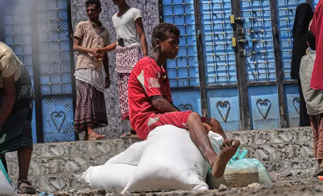 A displaced Yemeni boy sits on sacks of food aid in the Salah al-Din area on the outskirts of Aden, Yemen, Sunday, Oct. 25, 2026. (AP Photo/Abdulnasser Alseddik)
