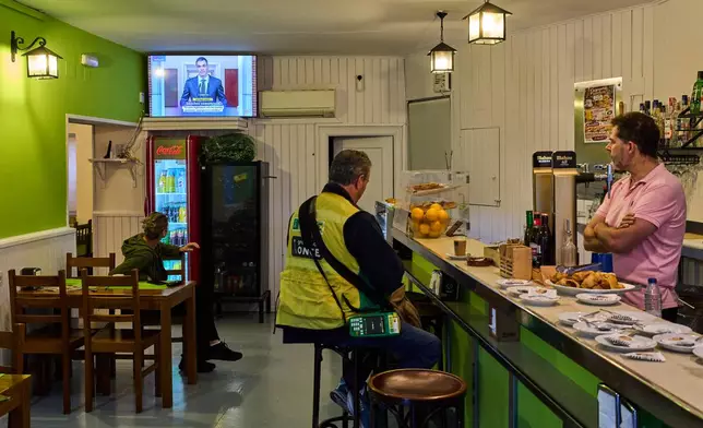 People at a bar in La Cabrera, on the outskirts of Madrid, Spain, watch a televised speech by Spanish Prime Minister Pedro Sanchez from La Moncloa Palace announcing national elections, Monday, Oct. 5, 2026. (AP Photo/Bernat Armangue)