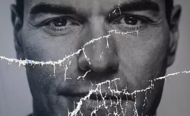 FILE - A partially damaged poster of Spanish Prime Minister and Socialist Party candidate Pedro Sanchez flaps in Parla, on the outskirts of Madrid, Spain, April 26, 2019. (AP Photo/Bernat Armangue, File)