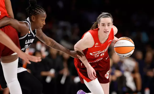 Indiana Fever guard Caitlin Clark (22) drives against Las Vegas Aces guard Jewell Loyd (24) during the first half in Game 3 of an WNBA basketball first-round playoff series Thursday, Oct.1, 2026, in Las Vegas. (AP Photo/Steve Marcus)