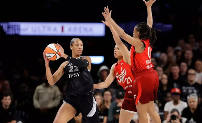 Las Vegas Aces center A'ja Wilson (22) is pressured by Indiana Fever forward Makayla Timpson (21) and guard Kelsey Mitchell (0) during the first half in Game 3 of an WNBA basketball first-round playoff series Thursday, Oct.1, 2026, in Las Vegas. (AP Photo/Steve Marcus)