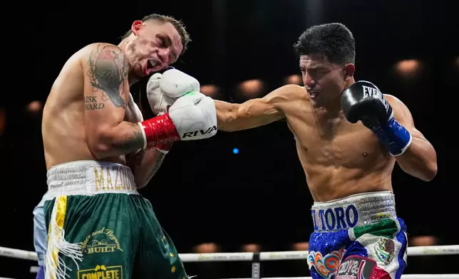 Koen Mazoudier, left, takes a punch from Armando Resendiz during a super middleweight boxing match Saturday, Oct. 17, 2026, in Las Vegas. (AP Photo/John Locher)