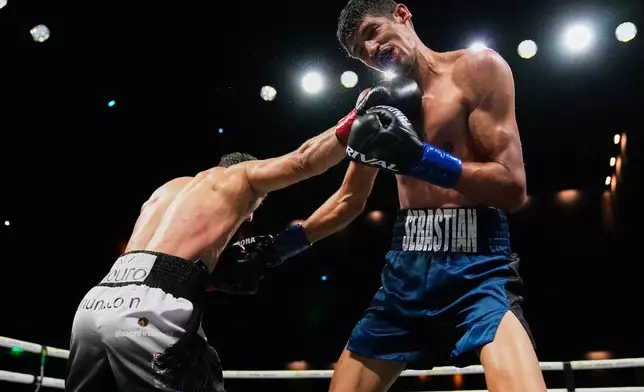Sebastian Fundora, right, takes a punch from Ermal Hadribeaj during a super welterweight championship boxing match Saturday, Oct. 17, 2026, in Las Vegas. (AP Photo/John Locher)