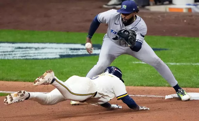 Milwaukee Brewers' David Hamilton is tagged out by Tampa Bay Rays third baseman Junior Caminero trying to advance on a double during the fifth inning of Game 1 of baseball's World Series, Friday, Oct. 23, 2026, in Milwaukee, between the Milwaukee Brewers and the Tampa Bay Rays. (AP Photo/David J. Phillip)