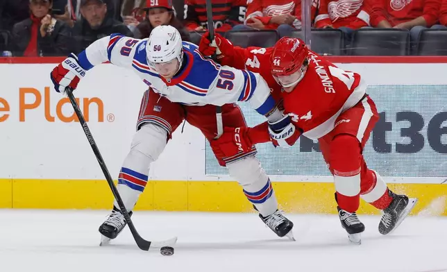 New York Rangers left wing Will Cuylle (50) tries to hold off Detroit Red Wings defenseman Axel Sandin-Pellikka (44) while chasing the puck during the first period of an NHL hockey game Friday, Oct. 2, 2026, in Detroit. (AP Photo/Duane Burleson)