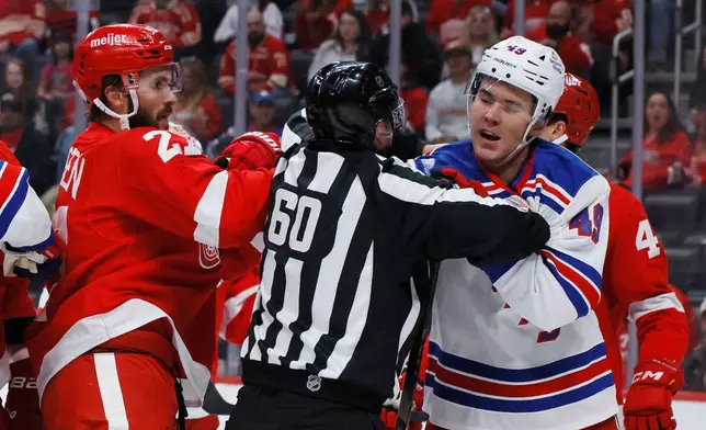 Detroit Red Wings center Michael Rasmussen, left, and New York Rangers right wing Jaroslav Chmelar (49) are separated by linesman Libor Suchanek (60) while fighting during the first period of an NHL hockey game Friday, Oct. 2, 2026, in Detroit. (AP Photo/Duane Burleson)