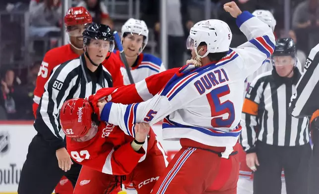 Detroit Red Wings center Marco Kasper (92) and New York Rangers defenseman Sean Durzi (5) fight during the second period of an NHL hockey game Friday, Oct. 2, 2026, in Detroit. (AP Photo/Duane Burleson)