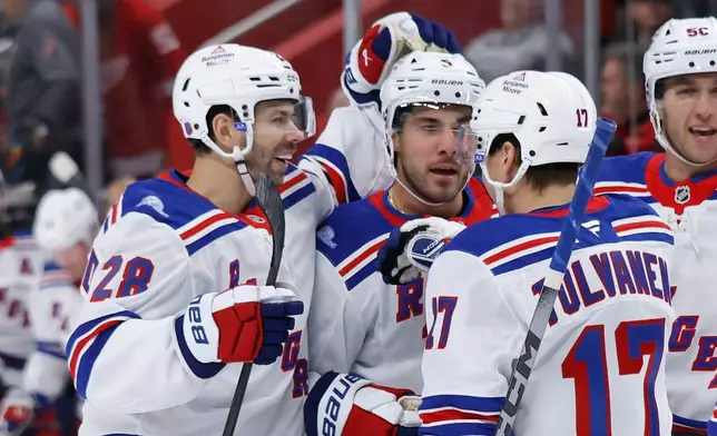 New York Rangers defenseman Sean Durzi, center, celebrates with right wing Oliver Bjorkstrand (28) and right wing Eeli Tolvanen (17) after scoring against the Detroit Red Wings during the first period of an NHL hockey game Friday, Oct. 2, 2026, in Detroit. (AP Photo/Duane Burleson)