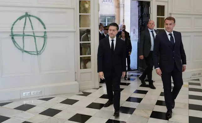 French President Emmanuel Macron, right, and Marseille Mayor Benoit Payan enter the city hall after it was vandalized, in Marseille, France, Monday, Oct. 26, 2026. (AP Photo/Aurelien Morissard, Pool)