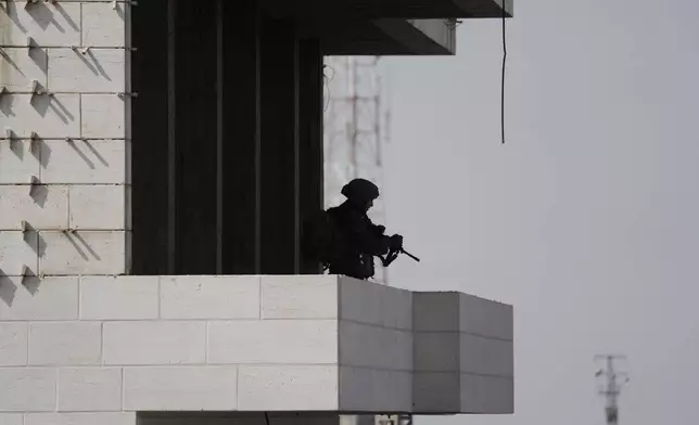 Israeli soldiers take up positions during an army operation in the West Bank city of Hebron Saturday, Oct. 24, 2026. A day after a Palestinian shooting attack in the area. (AP Photo/Mahmoud Illean)