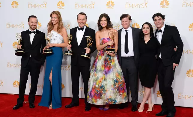 FILE - Aaron Paul, from left, Anna Gunn, Bryan Cranston, Betsy Brandt, Jesse Plemons, Laura Fraser and RJ Mitte pose in the press room with the award for outstanding drama series for "Breaking Bad" at the 66th Annual Primetime Emmy Awards at the Nokia Theatre L.A. Live, Aug. 25, 2014, in Los Angeles. (Photo by Jordan Strauss/Invision/AP, File)