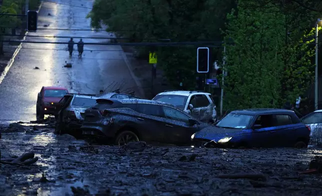 Vehicles are partially inundated in muddy floodwaters after heavy rains caused flash flooding in the Las Condes district of Santiago, Chile, Thursday, Oct. 8, 2026. (AP Photo/Esteban Felix)