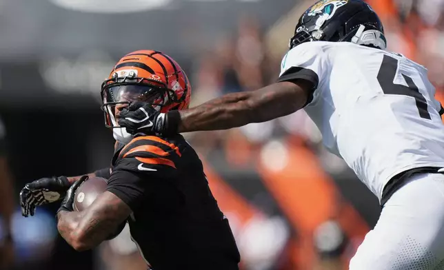 Jacksonville Jaguars cornerback Jarrian Jones (4) gets a face mask penalty against Cincinnati Bengals wide receiver Ja'marr Chase (1) during an NFL football game in Cincinnati, Sunday, Oct. 4, 2026. (AP Photo/Joshua A. Bickel)