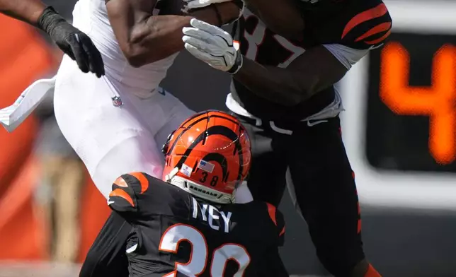 Cincinnati Bengals PJ Jules (37) and D.J. Ivey (38) tackle Jacksonville Jaguars wide receiver Josh Cameron (19) during an NFL football game in Cincinnati, Sunday, Oct. 4, 2026. (AP Photo/Joshua A. Bickel)