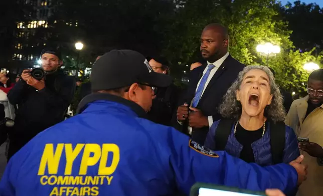 A woman is restrained before the start of a vigil marking the third anniversary of the October 7 attacks on Israel Wednesday, Oct. 7, 2026, in New York. (AP Photo/Frank Franklin II)