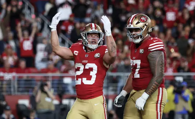San Francisco 49ers running back Christian McCaffrey (23) celebrates after scoring a touchdown next to guard Dominick Puni (77) during the first half of an NFL football game against the Washington Commanders in Santa Clara, Calif., Monday, Oct. 19, 2026. (AP Photo/Jed Jacobsohn)
