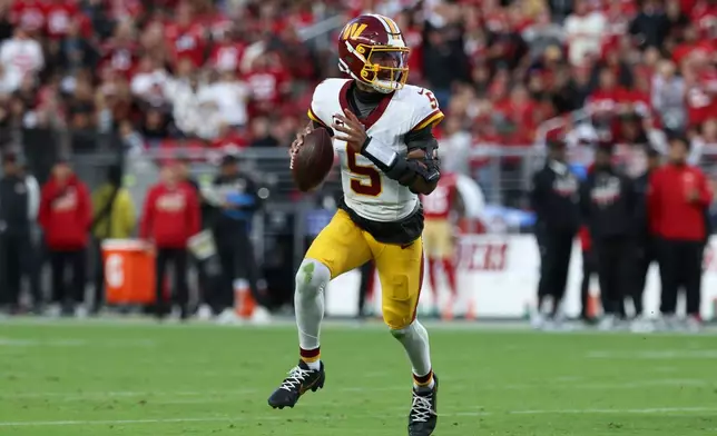 Washington Commanders quarterback Jayden Daniels (5) rolls out to pass against the San Francisco 49ers during the first half of an NFL football game in Santa Clara, Calif., Monday, Oct. 19, 2026. (AP Photo/Jed Jacobsohn)