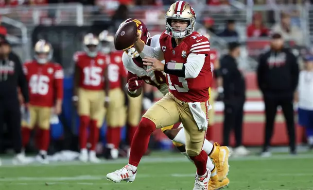 San Francisco 49ers quarterback Brock Purdy (13) scrambles while pressured against the Washington Commanders during the first half of an NFL football game in Santa Clara, Calif., Monday, Oct. 19, 2026. (AP Photo/Jed Jacobsohn)