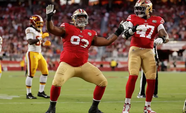 San Francisco 49ers defensive tackle Gracen Halton, middle, celebrates with defensive end Khalid Kareem (47) after sacking Washington Commanders quarterback Jayden Daniels during the first half of an NFL football game in Santa Clara, Calif., Monday, Oct. 19, 2026. (AP Photo/Kelley L. Cox)