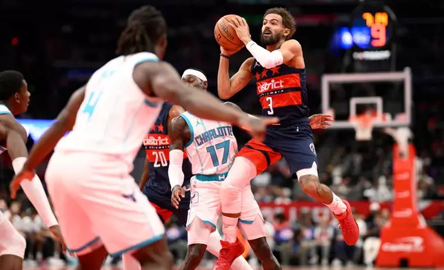 Washington Wizards guard Trae Young (3) looks to pass the ball against Charlotte Hornets guard Dennis Schroder (17) during the first half of an NBA Cup basketball game, Friday, Oct. 30, 2026, in Washington. (AP Photo/Nick Wass)