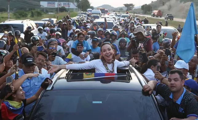 Supporters surround Venezuelan opposition leader and Nobel Peace Prize laureate Maria Corina Machado in Valencia, Venezuela, Sunday, Oct. 25, 2026, following her return to the country after months abroad. (AP Photo/Pedro Mattey)