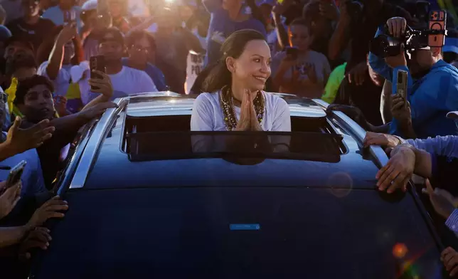 Supporters surround Venezuelan opposition leader and Nobel Peace Prize laureate Maria Corina Machado in Valencia, Venezuela, following her return to the country after months abroad, Sunday, Oct. 25, 2026. (AP Photo/Pedro Mattey)