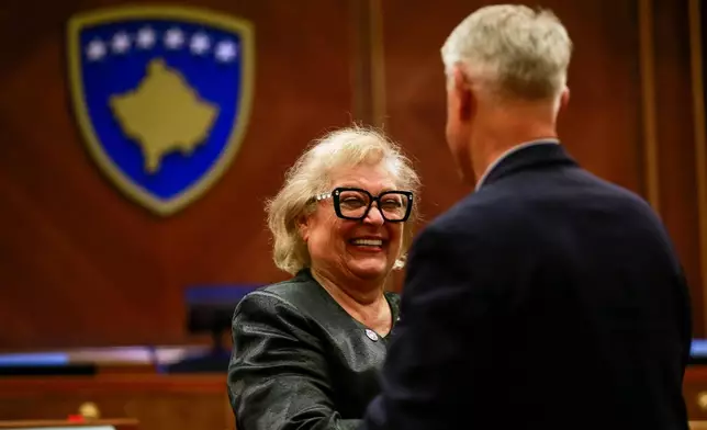 Kosovo lawmaker congratulates newly elected Kosovo's President Justina Shiroka Pula, center, in Kosovo's capital Pristina on Tuesday, Oct. 6, 2026. (AP Photo/Visar Kryeziu)