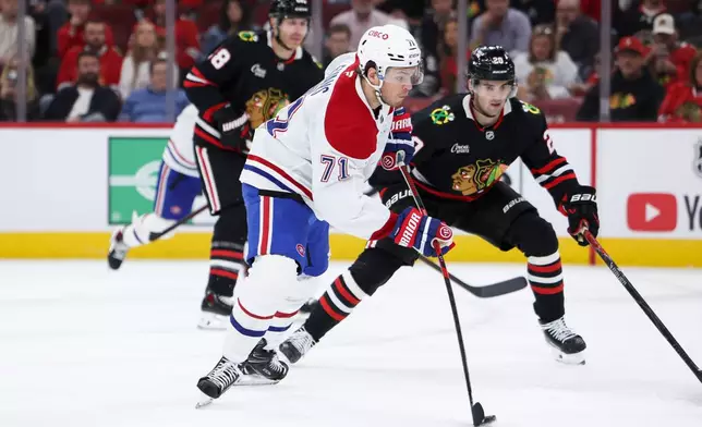 Montreal Canadiens center Jake Evans (71) shoots against Chicago Blackhawks center Ryan Greene, right, during the first period of an NHL hockey game, Friday, Oct. 23, 2026, in Chicago. (AP Photo/Jessie Alcheh)