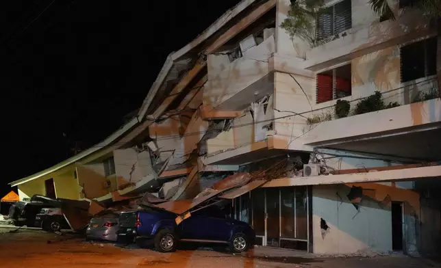 Vehicles lie crushed beneath a collapsed hotel after an earthquake struck Penonome, Panama, Friday, Oct. 9, 2026. (AP Photo/Aris Mariota)