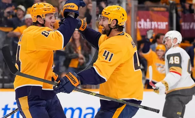 Nashville Predators center Adam Edstrom (84) celebrates his short-handed goal with defenseman Nicolas Hague (41) during the second period of an NHL hockey game against the Vegas Golden Knights, Tuesday, Oct. 13, 2026, in Nashville, Tenn. (AP Photo/George Walker IV)