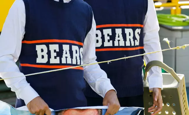 A pair of Chicago Bears fans pay tribute to Mike Ditka before an NFL football game against the Green Bay Packers in Green Bay, Wis., Sunday, Oct. 11, 2026. (AP Photo/Jeffrey Phelps)