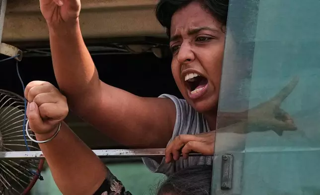 Detained youth protesters shout slogans as police drive them away in a van from a demonstration by the Cockroach Janta Party demanding the resignation of Chief Election Commissioner Gyanesh Kumar in New Delhi, India, Saturday, Oct. 10, 2026. (AP Photo/Manish Swarup)