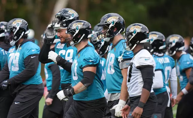 Jacksonville Jaguars' team members work out during an NFL football practice in Hertfordshire, England, Wednesday, Oct. 14, 2026. (AP Photo/Kin Cheung)