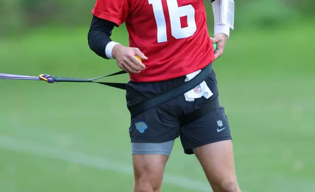Jacksonville Jaguars quarterback Trevor Lawrence (16) during an NFL football practice in Hertfordshire, England, Friday, Oct. 16, 2026. (AP Photo/Adam Bettcher)