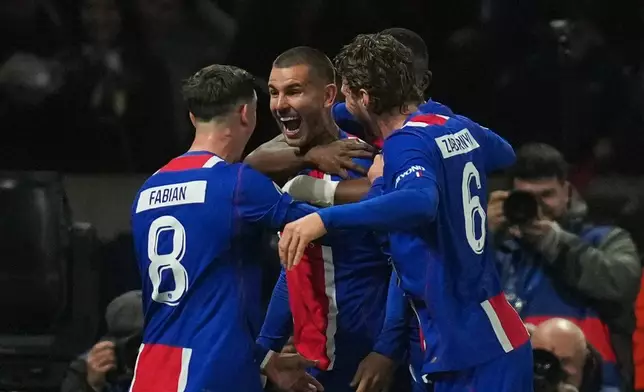 PSG's Lucas Hernandez, center, celebrates after scoring his side's second goal during the Champions League opening phase soccer match between Paris Saint-Germain and FC Barcelona in Paris, Tuesday, Oct. 20, 2026. (AP Photo/Thibault Camus)