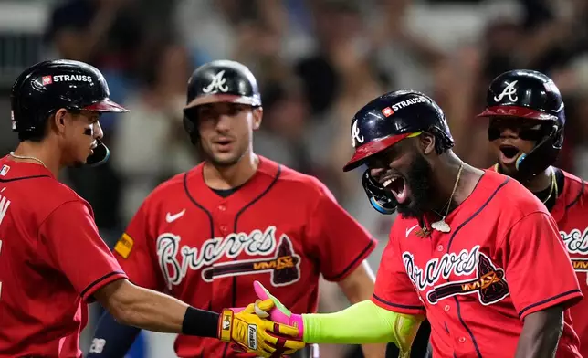 Atlanta Braves' Michael Harris II, third from left, celebrates his three-run home run with Mauricio Dubón (14), Matt Olson, second from left, and Ronald Acuña Jr., right, against the Philadelphia Phillies in the first inning during Game 3 of baseball's NL Wild Card Series, Thursday, Oct. 1, 2026, in Atlanta. (AP Photo/Brynn Anderson)