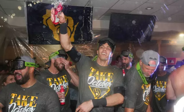 Milwaukee Brewers' Christian Yelich, center celebrates with teammates after the team defeated the San Diego Padres in Game 4 of baseball's National League Division Series Wednesday, Oct. 7, 2026, in San Diego, to advance to the National League Championship Series. (AP Photo/Gregory Bull)