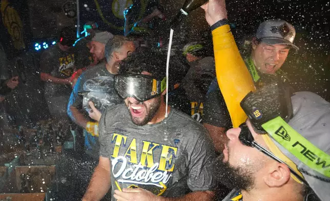 Milwaukee Brewers players celebrate after the team defeated the San Diego Padres in Game 4 of baseball's National League Division Series Wednesday, Oct. 7, 2026, in San Diego, to advance to the National League Championship Series. (AP Photo/Gregory Bull)