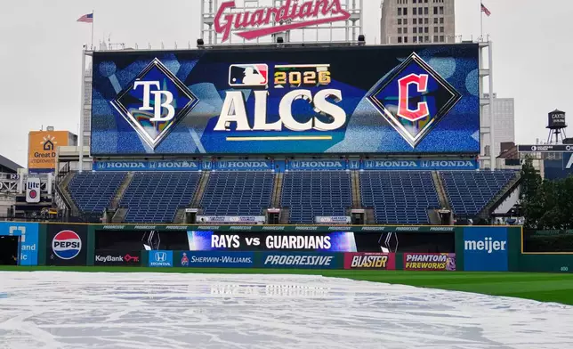 A tarp covers the field the day before Game 3 of baseball's American League Champions Series between the Tampa Bay Rays and Cleveland Guardians, Wednesday, Oct. 14, 2026, in Cleveland. (AP Photo/Sue Ogrocki)