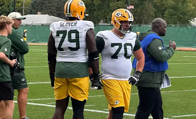 Green Bay Packers guard Kevin Zeitler (70) walks past fellow lineman Travis Glover on the sideline during practice Wednesday, Sept. 30, 2026, in Green Bay, Wis. (AP Photo/Steve Megargee)