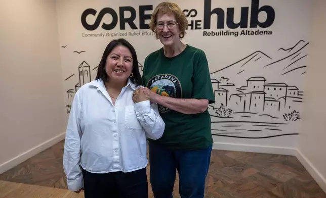 Veda Ashby Romero, left, a disaster case manager for CORE, poses for a portrait with Mary Landau, a fire survivor, at the CORE resource center on Thursday, Oct. 15, 2026, in Altadena, Calif. (AP Photo/Jill Connelly)