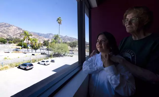 Veda Ashby Romero, left, a disaster case manager for CORE, poses for a portrait with Mary Landau, a fire survivor, at the CORE resource center on Thursday, Oct. 15, 2026, in Altadena, Calif. (AP Photo/Jill Connelly)