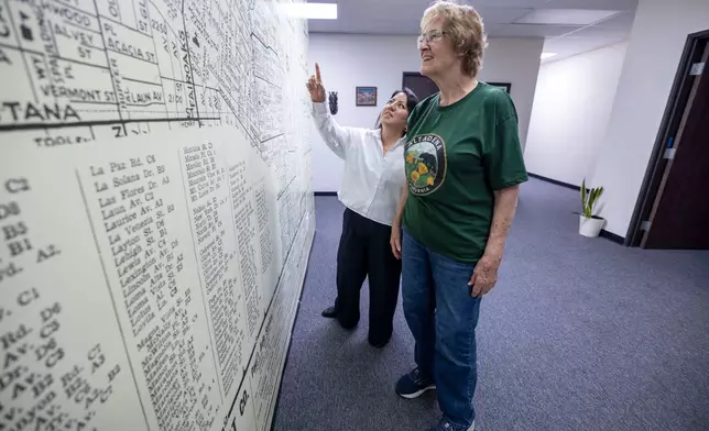 Mary Landau, a fire survivor, and Veda Ashby Romero, a disaster case manager for CORE, look at the Altadena map at the CORE resource center on Thursday, Oct. 15, 2026, in Altadena, Calif. (AP Photo/Jill Connelly)