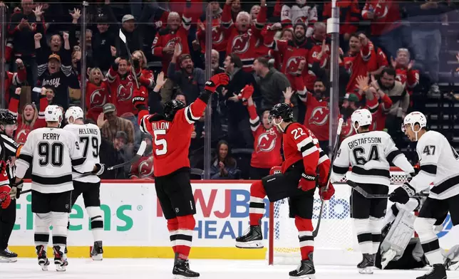 New Jersey Devils defenseman Brett Pesce (22) reacts after scoring a goal during the third period of an NHL hockey game against the Los Angeles Kings, Saturday, Oct. 24, 2026, in Newark, N.J. (AP Photo/Adam Hunger)