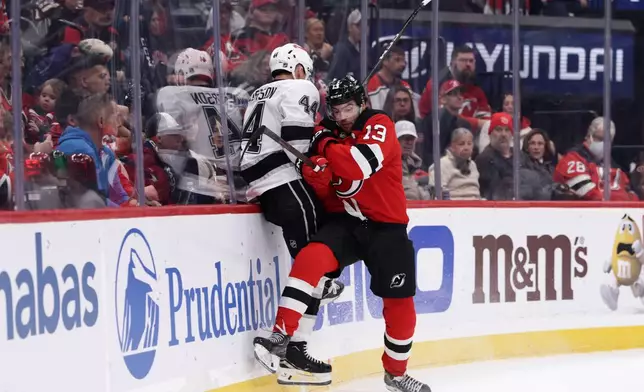 New Jersey Devils center Nico Hischier (13) checks Los Angeles Kings defenseman Mikey Anderson (44) during the second period of an NHL hockey game Saturday, Oct. 24, 2026, in Newark, N.J. (AP Photo/Adam Hunger)