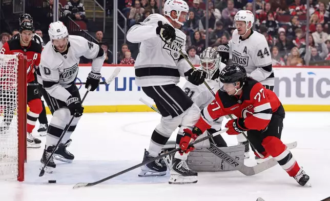 Los Angeles Kings right wing Joel Armia (40) stops a shot from getting past goaltender Anton Forsberg (31) in front of New Jersey Devils right wing Luke Evangelista (77) during the second period of an NHL hockey game Saturday, Oct. 24, 2026, in Newark, N.J. (AP Photo/Adam Hunger)
