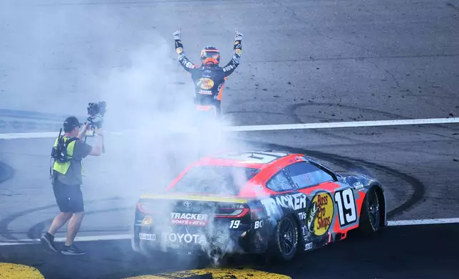 Chase Briscoe, right, salutes fans after winning a NASCAR Cup Series auto race Sunday, Oct. 4, 2026, in Las Vegas. (AP Photo/Sam Morris)