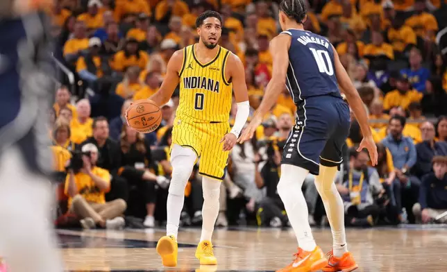 Indiana Pacers guard Tyrese Haliburton (0) brings the ball up in front of Dallas Mavericks forward Zaccharie Risacher (10) during the first half of an NBA basketball game in Indianapolis, Friday, Oct. 23, 2026. (AP Photo/AJ Mast)
